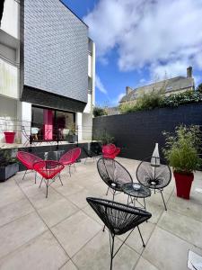 a group of chairs and tables on a patio at Le Cornouaille Hotel & Spa in Bénodet