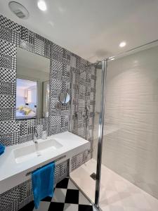 a bathroom with a sink and a shower at Le Cornouaille Hotel & Spa in Bénodet