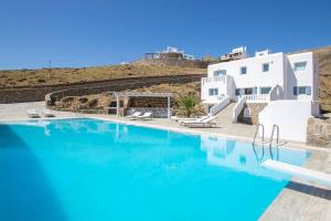 a swimming pool with blue water in front of a building at Villa Anatoli in Mikonos