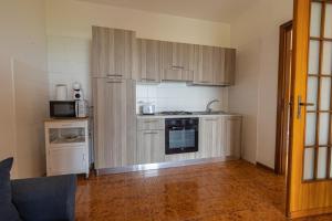 a kitchen with wooden cabinets and a stove top oven at 2-Casa sul mare con piscina vicino Cefalù in Campofelice di Roccella