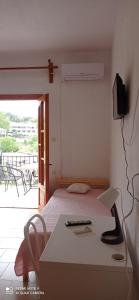 a bedroom with a bed and a desk with a computer at Kandilari Apartments in Kókkinon Nerón