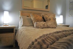 a bedroom with a bed with two lamps and a mirror at 201 Hexrivier in Hartenbos