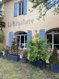 een gebouw met planten in potten ervoor bij Logis Hotel Restaurant Le Domaine de la Régalière in Anduze