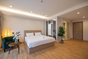 um quarto com uma cama, uma cadeira e uma mesa em Exoresidence The Heart of Chinatown em Bangkok