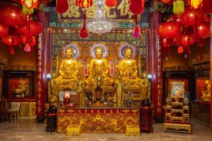 een tempel met gouden beelden in een kamer met verlichting bij Exoresidence The Heart of Chinatown in Bangkok