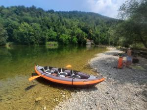 an orange boat sitting on the shore of a river at SUN RIVER KOLPA Ap2 in Vinica