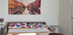 een bed in een kamer met een schilderij aan de muur bij Your Way in Venice in Mestre