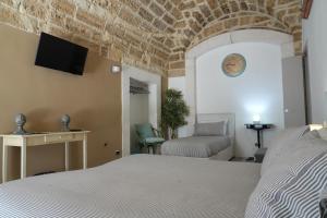 1 dormitorio con 1 cama y TV en la pared en B&B Il Grifone, en Gioia del Colle