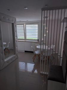ein Esszimmer mit einem Tisch, Stühlen und Fenstern in der Unterkunft Apartament Frombork in Frombork