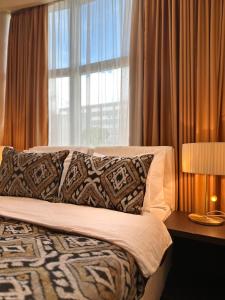 a bedroom with a bed with a large window at Hotel Alexandar Lux in Podgorica