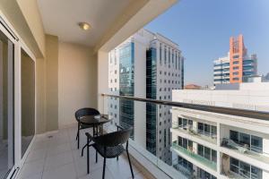 balcón con 2 sillas y vistas a la ciudad en City Stay Prime Hotel Apartments - Al Barsha, en Dubái