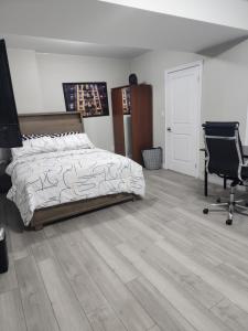 Schlafzimmer mit einem Bett, einem Schreibtisch und einem Stuhl in der Unterkunft Modern Apartment London Ontario in London