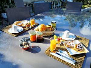 una mesa con alimentos para el desayuno y zumo de naranja en ella en Villa Bayarde, en Figanières