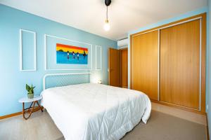 a bedroom with a bed and a painting on the wall at Oasis beach apartment in Figueira da Foz