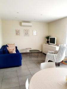 Bompas的住宿－Appartement plein pied climatisé dans maison catalane，客厅配有蓝色的沙发和椅子