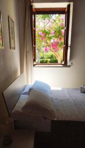 a bedroom with a bed and a window with pink flowers at Podere Il Ritorno in Portoferraio
