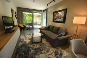 sala de estar con sofá y TV en Olive Apartman, en Alsóörs