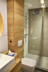 een badkamer met een douche, een toilet en een wastafel bij Olive Apartman in Alsóörs
