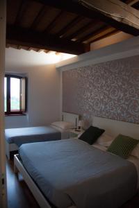 1 dormitorio con 2 camas y pared en Mamma Dò, en Gualdo Tadino