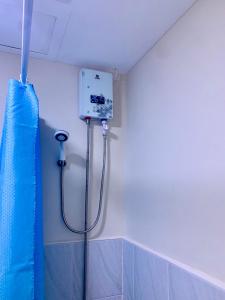 La salle de bains est pourvue d'une douche et d'un rideau de douche bleu. dans l'établissement Condo Near Mactan Airport, à Cebu
