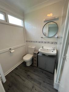 a bathroom with a toilet and a sink and a mirror at 82, Belle Aire, Hemsby - Two bed chalet, sleeps 5, bed linen and towels included - pet friendly in Great Yarmouth