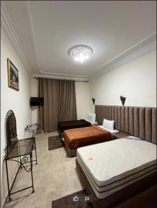 Habitación de hotel con 2 camas y sofá en Hotel Jnan Arfoud, en Erfoud
