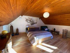 a bedroom with a bed and a wooden ceiling at La coume du cerf in Campan