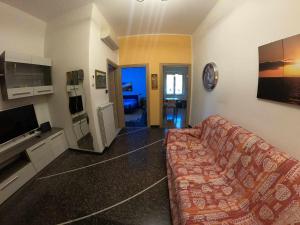 een woonkamer met een bank en een tv bij Apartment Gentile a 200 metri dal mare in Albissola Marina
