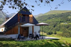 a house with two chairs and two umbrellas at La coume du cerf in Campan