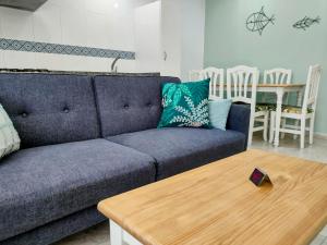 - un salon avec un canapé bleu et une table en bois dans l'établissement Apartamentos Rodeiramar 2A, à Cangas