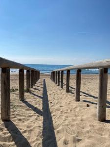 a wooden pier on a beach with the ocean at Casa vacanze Nina in Torre Ovo