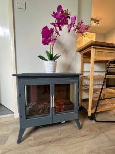 a fireplace in a living room with flowers on top at 82, Belle Aire, Hemsby - Two bed chalet, sleeps 5, bed linen and towels included - pet friendly in Great Yarmouth