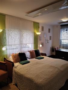 a bedroom with a large bed with green curtains at KultúrÉlet Vendégháza in Kétegyháza