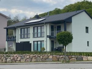 ein weißes Haus mit schwarzem Dach in der Unterkunft Haus Edith in Sassnitz