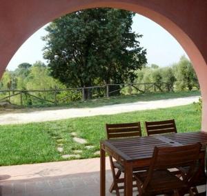 una mesa de madera y 2 sillas de forma arqueada en Agriturismo Podere La Casa, en Palaia