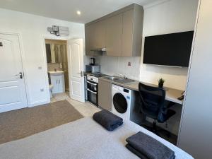 een kamer met een keuken, een bureau en een bed bij Bright Modern, 1 Bed Flat, 15 Mins Away From Central London in Hendon