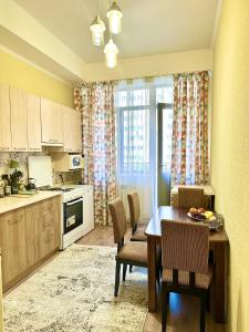 kuchnia ze stołem i krzesłami oraz kuchnia ze stołem i kuchnią w obiekcie Apartment Panfilov Center w mieście Biszkek