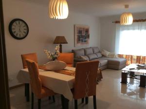 sala de estar con mesa y reloj en la pared en The Best Downtown Albufeira, en Albufeira