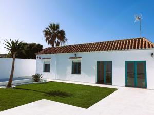 a white house with a yard and palm trees at Villa Turquesa in Zahora