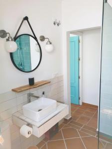 ein Bad mit einem Waschbecken und einem Spiegel in der Unterkunft Villa Turquesa in Zahora