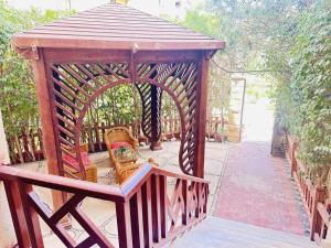 Casa Do Cairo - Rehab City في القاهرة: شرفة خشبية فيها كرسيين