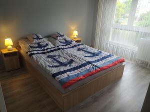 een bed in een slaapkamer met 2 lampen en een sprei bij Krénusz Vendégház 2. in Kaposvár