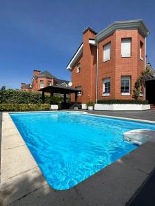 a blue swimming pool in front of a house at !Chalet de lujo para vacaciones!... in Camargo