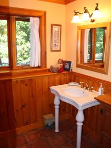 un baño con lavabo y una ventana con un vestido blanco colgando de una ventana. en Honey Maple Grove BnB, en Bedford