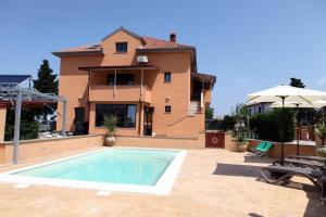 a villa with a swimming pool in front of a house at APARTMA JURICICH in Portorož