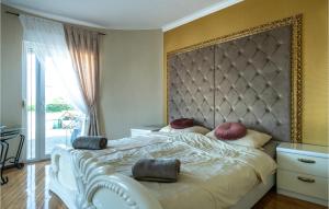 a bedroom with a large bed with a large headboard at Awesome Home In Valtursko Polje With Kitchen in Valtura