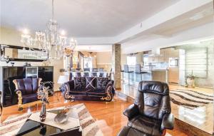 a living room with leather furniture and a chandelier at Awesome Home In Valtursko Polje With Kitchen in Valtura