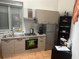 a kitchen with a sink and a stove top oven at Vanvitelli Home in Caserta