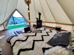 a large tent with a bed in a room at Rucăr Glamping Village in Rucăr