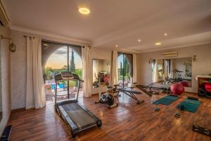 a gym with several treadmills and exercise equipment in a room at Taj Atlas Wellness Boutique Hôtel & Spa in Amizmiz